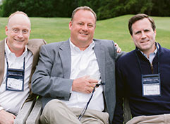 Photo of three men smiling for a picture. 